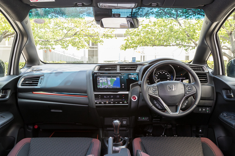 RS Honda SENSINGのインテリアでは、ブラック×オレンジのスポーティシートに加え、インパネ加飾やステアリング＆シフトノブのステッチ、ドアトリムなどにオレンジの加飾を使って活発なイメージを表現する