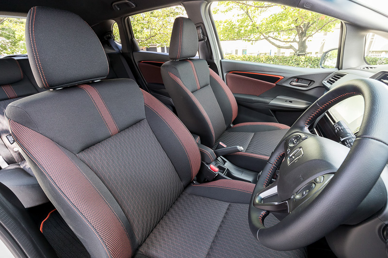RS Honda SENSINGのインテリアでは、ブラック×オレンジのスポーティシートに加え、インパネ加飾やステアリング＆シフトノブのステッチ、ドアトリムなどにオレンジの加飾を使って活発なイメージを表現する