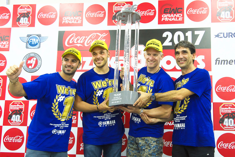 チャンピオントロフィーを掲げるGMT94 YAMAHAのライダー3人とチーム監督