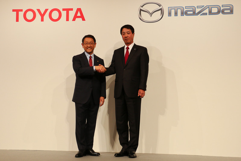 2015年5月に行なわれた会見で握手するトヨタ自動車株式会社 代表取締役社長 豊田章男氏（左）とマツダ 代表取締役社長兼CEO 小飼雅道氏（右）