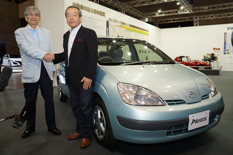 初代「プリウス」と記念撮影するトヨタ自動車株式会社 代表取締役会長 内山田竹志氏（右）と、自動車ライターの山口京一氏（左）