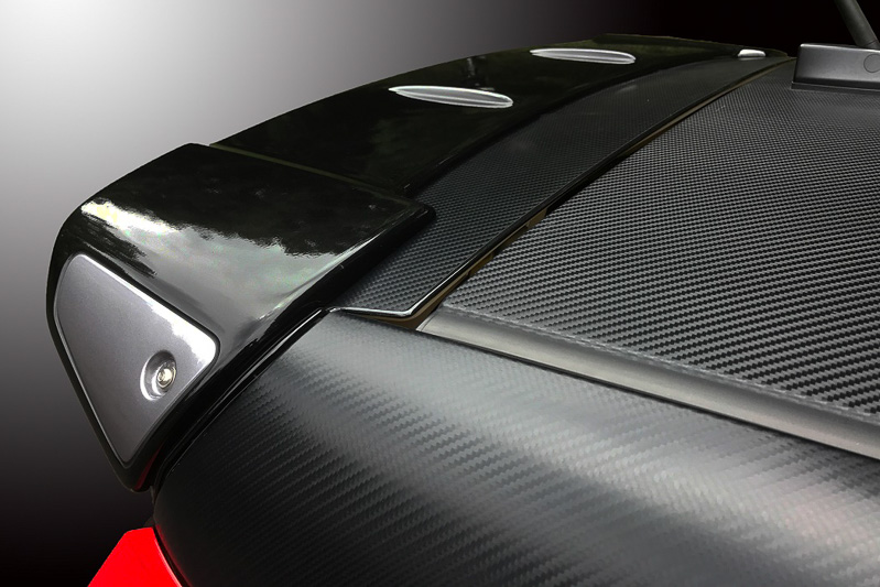 リアスポイラーを大型化するFRP製の「リヤルーフスポイラー」。塗装済品は純正色の「ブラックマイカメタリック」を基本に、両サイドの一部がガンメタリック塗装となる