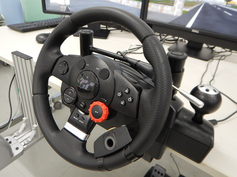 3台の液晶モニターを置くテーブルに、ステアリングと手動運転装置を固定。ステアリングには旋回ノブを追加できる
