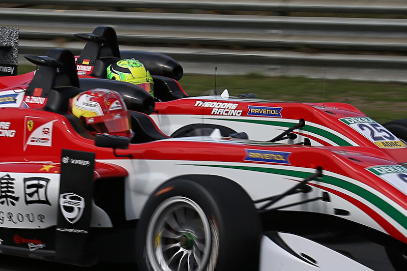 チームメイトのガン・ユーゾ選手にインを取られるミック・シューマッハ選手（奥）