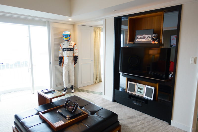 リビングルームの壁面にはレーシングスーツとヘルメットの展示