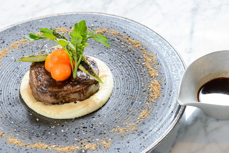 ［肉］ドライエイジ ブラックアンガス ビーフテンダーロイン 150g　山中牧場のバターミルクマッシュポテト　メープルキャロットのグラッセ　クミン　アスパラガス　ポアブラードソース（写真提供：ヒルトン東京お台場）