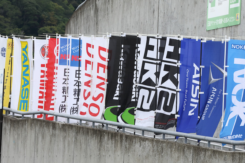 エコパスタジアム前には協賛企業が並ぶボードやのぼりとともに、国内フォーミュラレースの最高峰「スーパーフォーミュラ」のマシン「SF13」「SF14」も展示され、さまざまな技術系イベントが行なわれた