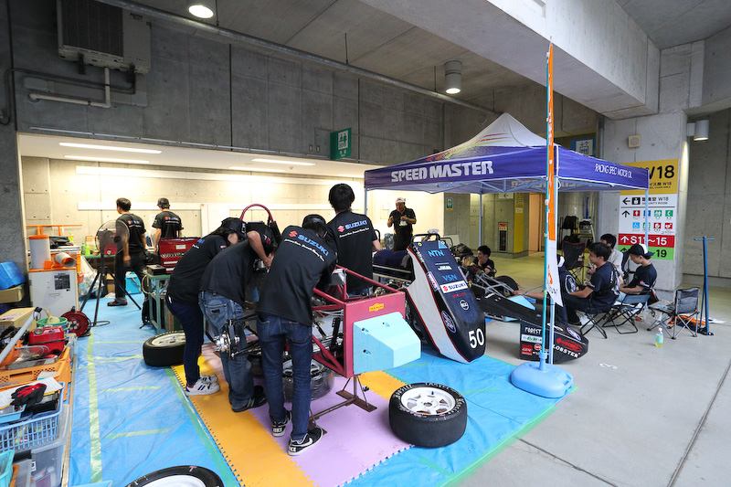 エコパスタジアムの2Fに割り当てられたピットで、車検を前に着々とマシンの整備を進める学生たち