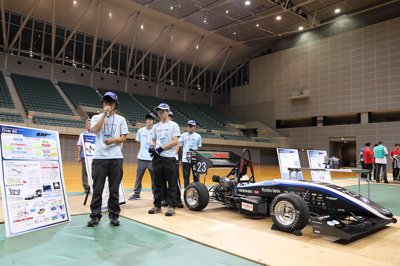 デザイン ファイナル イベントでプレゼンテーションを行なう3チーム。写真左から京都大学、名古屋大学EV、Harbin Institute of Technology at Weihei EV（中国）