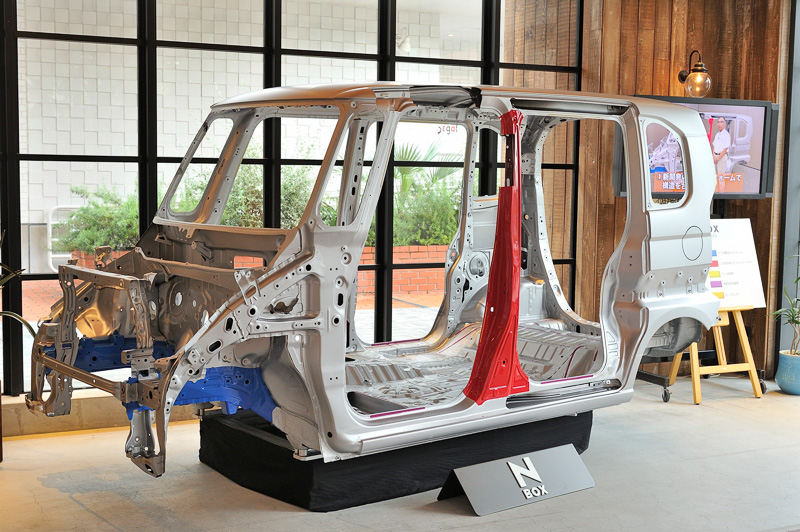 新型N-BOXのホワイトボディ。助手席のロングスライドを実現するため助手席からリアシートまでフロアがフラットに連続。さらに軽量・高剛性を実現するため、超高張力鋼板や高粘度接着剤の使用などさまざまな技術が用いられている