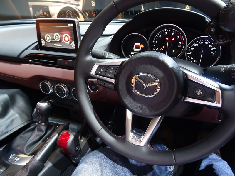 ロードスター RFとアテンザともに手だけで運転できる手動運転装置が付いている。よりスポーティな走りが楽しめるロードスターRFにはステアリングスポーク右に、親指で操作可能なシフトダウンボタンも装備