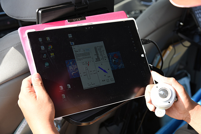 PCの画面。風向などが示されている。クルマの移動時も、移動データを補正し、正しい風力・風向が表示される。右の丸いのは日射計