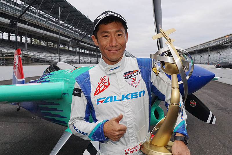 レッドブル・エアレースで世界チャンピオンを獲得。インディ500が開催される「モーター・スピードウェイ」コース上でトロフィーとともに記念撮影に応じる室屋義秀選手（No.31 チーム ファルケン）
