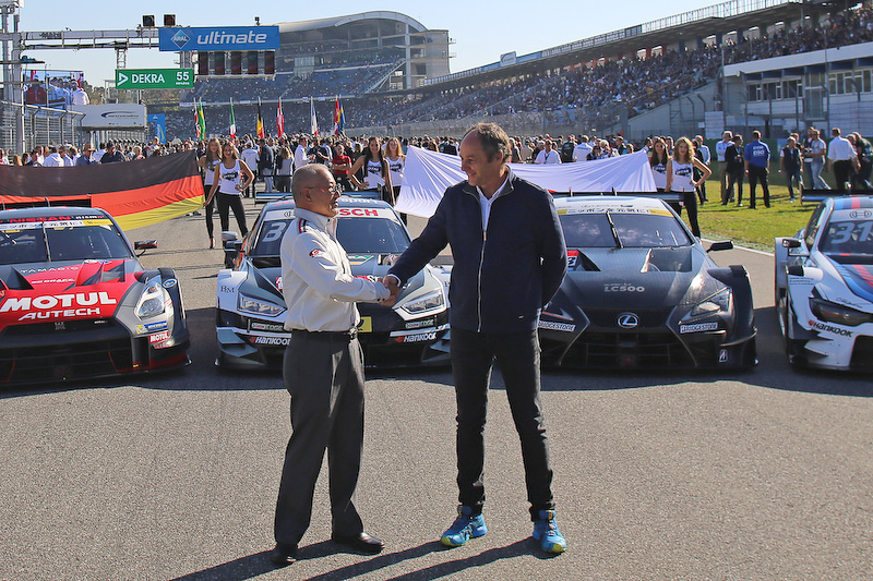 15日のレース前のセレモニーで、並んだGT500とDTMのマシンの前で握手する坂東正明代表とゲルハルト・ベルガー代表