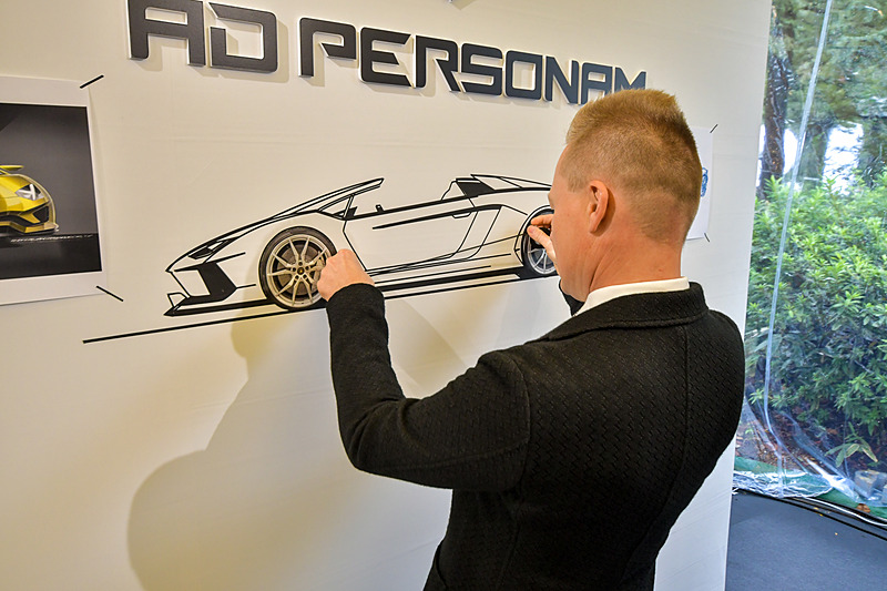 パネルの空間にデザインテープで絵を描くデザイン責任者のボルケルト氏