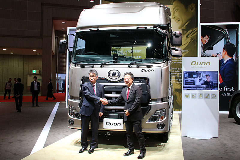 クオンの前に立つUDトラックス株式会社 代表取締役社長 村上吉弘氏（左）と、UDトラックステクノロジー シニア・バイスプレジデントのダグラス・ナカノ氏（右）