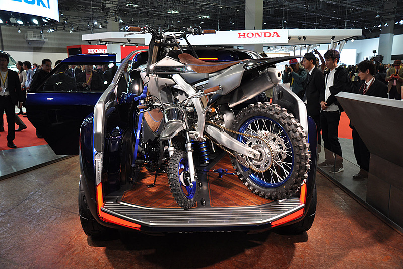 後部の広い荷台スペースには大小の競技用モデルを積載。奥のYZ250FXのスイングアームの下から青いサスペンションが見える