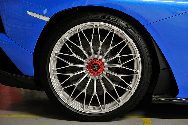 従来モデルの「アヴェンタドール」から空力性能をはじめエンジンおよびラジエター冷却の向上を図るべくフロントまわりのデザインを変更。リアまわりではブラックのディフューザーに垂直フィンを設定するとともに、可動式のアクティブリアウイングなどを搭載。こうした空力性能の改善により、アヴェンタドールからフロントのダウンフォースが130%、ダウンフォースの全体効率が50%(ウイングが最適な位置にある状態の場合)増加したという。ランボルギーニのシリーズ生産車として4輪ステアリングシステムを初採用したのもトピックの1つ。装着するピレリ「P ZERO」のサイズはフロントが255/30 ZR20、リアが355/25 ZR21