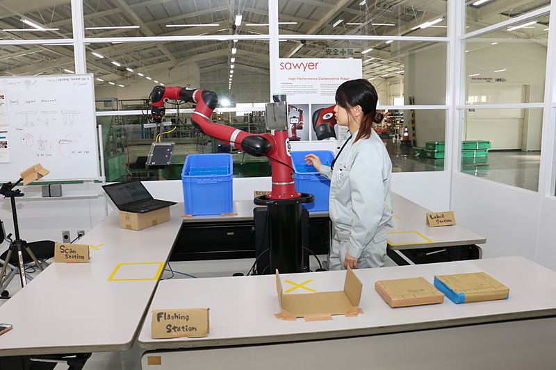 「青いボックスに入っているECUを取り出し、貼られたラベルをスキャナーで読み取って所定の位置に置く」という作業工程を想定して、動作のチェックなどをしているシーン