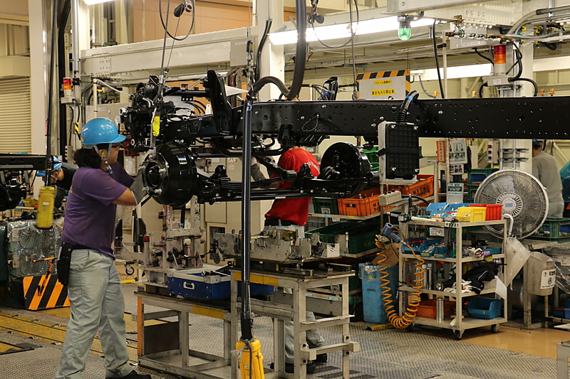 小型トラックは位置決めをした足まわりのところにシャシーフレームを運んできて組み付ける