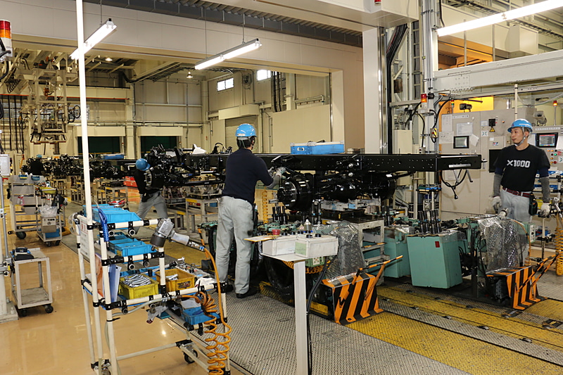 小型トラックは位置決めをした足まわりのところにシャシーフレームを運んできて組み付ける