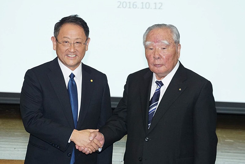 2016年10月12日に実施された共同会見で握手するトヨタ自動車 代表取締役社長 豊田章男氏（左）とスズキ 代表取締役会長 鈴木修氏（右）