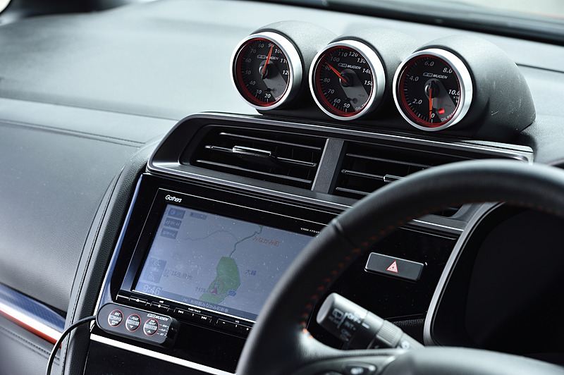 つや消し塗装の専用メーターフードが用意される3連仕様の「アシストメーター」（14万400円）。各60φの水温、油温、油圧メーターがセットになる。カーナビ画面の下にあるのが設定変更などの操作を行なうスイッチユニット