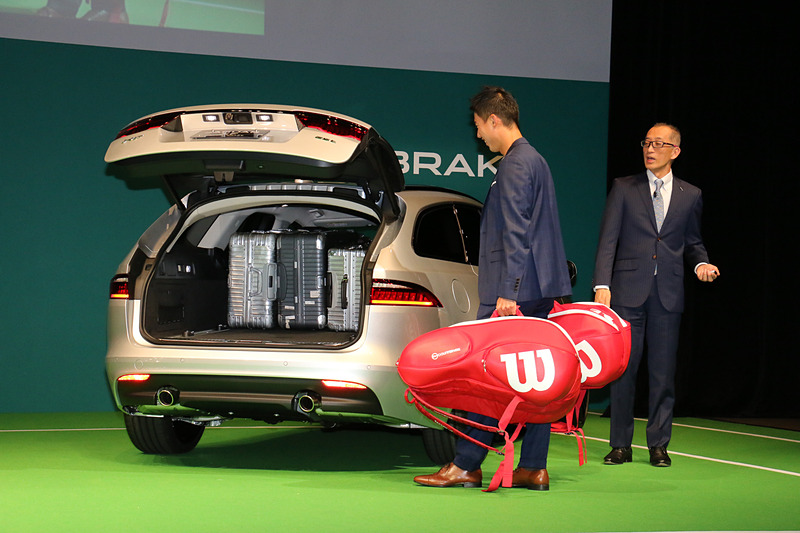 両手にテニスラケットを収納するバッグを持った錦織選手が、XF スポーツブレイクのリアバンパーの側面から足先を差し込むような動作をすると、リアハッチが電動オープン。両手のバッグをそのまま搭載できた。また、リアハッチが開いているときに同様の動作をすると電動クローズすることも披露された