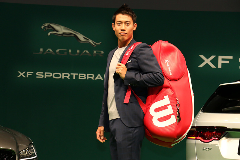 ラケットバッグを背負ってジャガーブランドチャームを紹介。ジャガーのブランドロゴが滑らかな金属で立体化されている