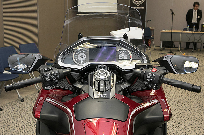 新型ゴールドウイングのハンドルまわり。メーターは視認性重視のアナログ式。中央にはフルカラー7インチTFT液晶モニターが付く。センターコンソールスイッチにはイグニッションや各種装置の操作スイッチが並ぶ