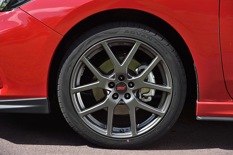 ガンメタリック色のSTI17インチアルミホイール（税別16万8000円/台）に、225/40 R18サイズの橫浜ゴム「ADVAN Sport V105」を装着。白いSTIロゴが1つ1つに入る「STIホイールナットセット」は2万円（税別）