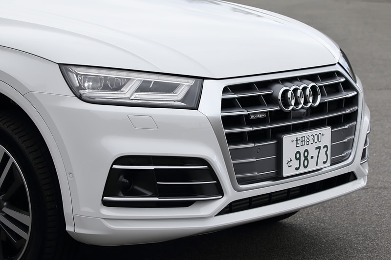 新しいQ5シリーズではフロントグリル（写真中央）やドアミラー、リアハッチなどのカメラ、フロントバンパー両サイドのレーダーセンサー（写真右）などに加え、フロントウィンドウのカメラ、前後の超音波センサーなどを標準装備。アダプティブクルーズコントロール、アウディ プレゼンス シティ、アウディ プレゼンス リア、サラウンドビューカメラなどの先進装備を機能させる