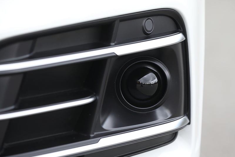 新しいQ5シリーズではフロントグリル（写真中央）やドアミラー、リアハッチなどのカメラ、フロントバンパー両サイドのレーダーセンサー（写真右）などに加え、フロントウィンドウのカメラ、前後の超音波センサーなどを標準装備。アダプティブクルーズコントロール、アウディ プレゼンス シティ、アウディ プレゼンス リア、サラウンドビューカメラなどの先進装備を機能させる