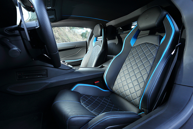 ブラックを基調にした精悍なインテリア。シートステッチなど要所にボディカラーと同色の加飾が与えられるほか、オプションの「インテリア・カーボンファイバー・フルパッケージ」（128万5740円）の装着でよりスパルタンに仕上がっている