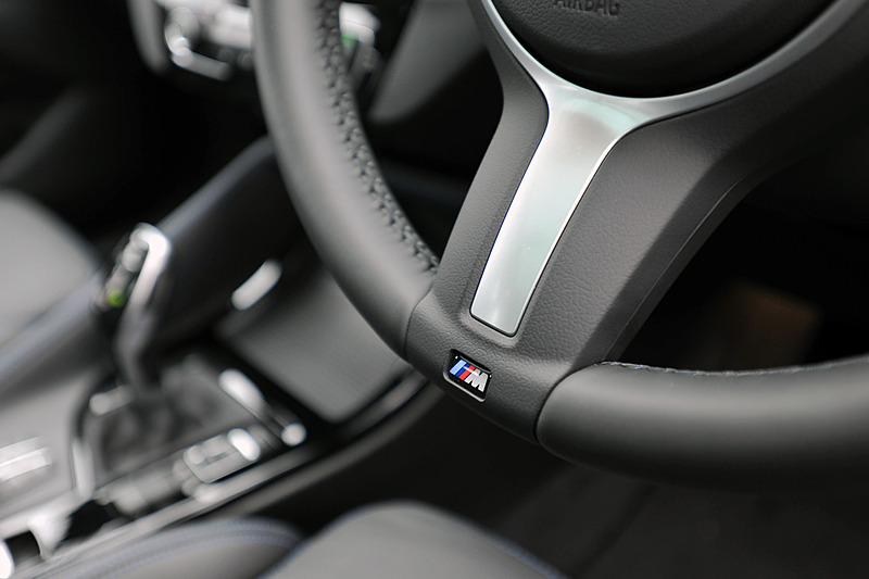 ブラックを基調にしたインテリア。M Sport仕様では前席スポーツシートやMスポーツ・レザー・ステアリング・ホイールなどを標準装備。撮影車はブルーステッチ入りのパーフォレーテッド・ダコタ・レザー・シート（ブラック）を装備