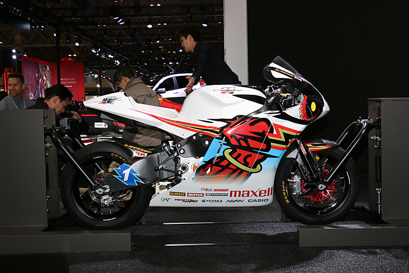 「マン島TTレース」参戦の電動バイク「神電 四」は、実際に車両にまたがって、マン島を走行する映像に合わせて右左にハングオンする体験コーナーに利用されていた