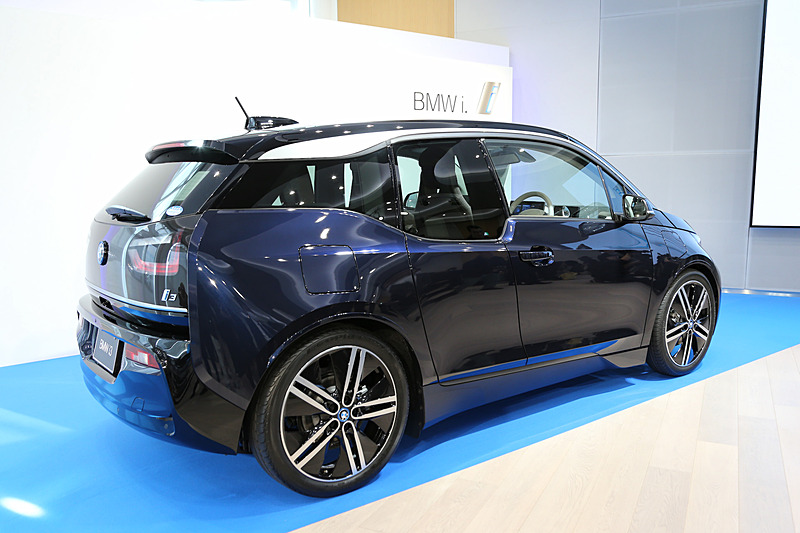 新型i3（LODGE）のレンジエクステンダー装着車。ボディサイズは4020×1775×1550mm（全長×全幅×全高）、ホイールベースは2570mm。車両重量はピュアEVのi3よりも120kg重い1420kg。新型i3では、2016年から採用している33kWhのリチウムイオンバッテリーを搭載し、1回あたりの充電走行距離は390km。モーターは最高出力125kW/170PS、最大トルク250Nmを発生し、ハイブリッド燃料消費率（JC08モード燃費）は24.7km/L