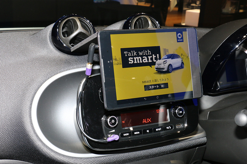 デジタルセールス・プロジェクトでは、車両に搭載されているAI（人工知能）と対話するスタイルでスマートが持つ魅力などを解説。また、ディスプレイに備えたカメラで記念撮影して、AIが写真を登録したメールアドレス宛に送るデモも行なわれていた