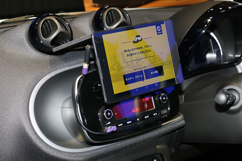 デジタルセールス・プロジェクトでは、車両に搭載されているAI（人工知能）と対話するスタイルでスマートが持つ魅力などを解説。また、ディスプレイに備えたカメラで記念撮影して、AIが写真を登録したメールアドレス宛に送るデモも行なわれていた