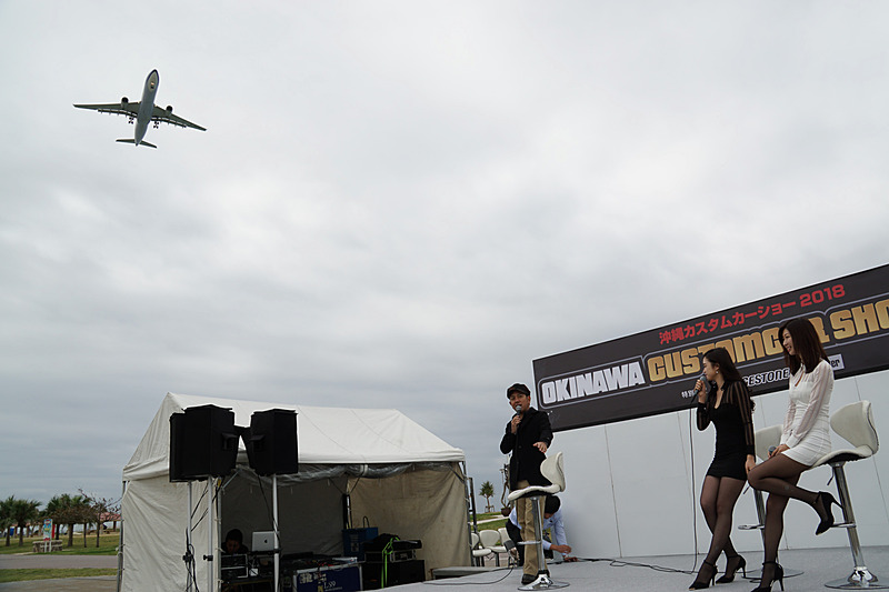那覇空港に着陸する飛行機が会場の真上を通過する