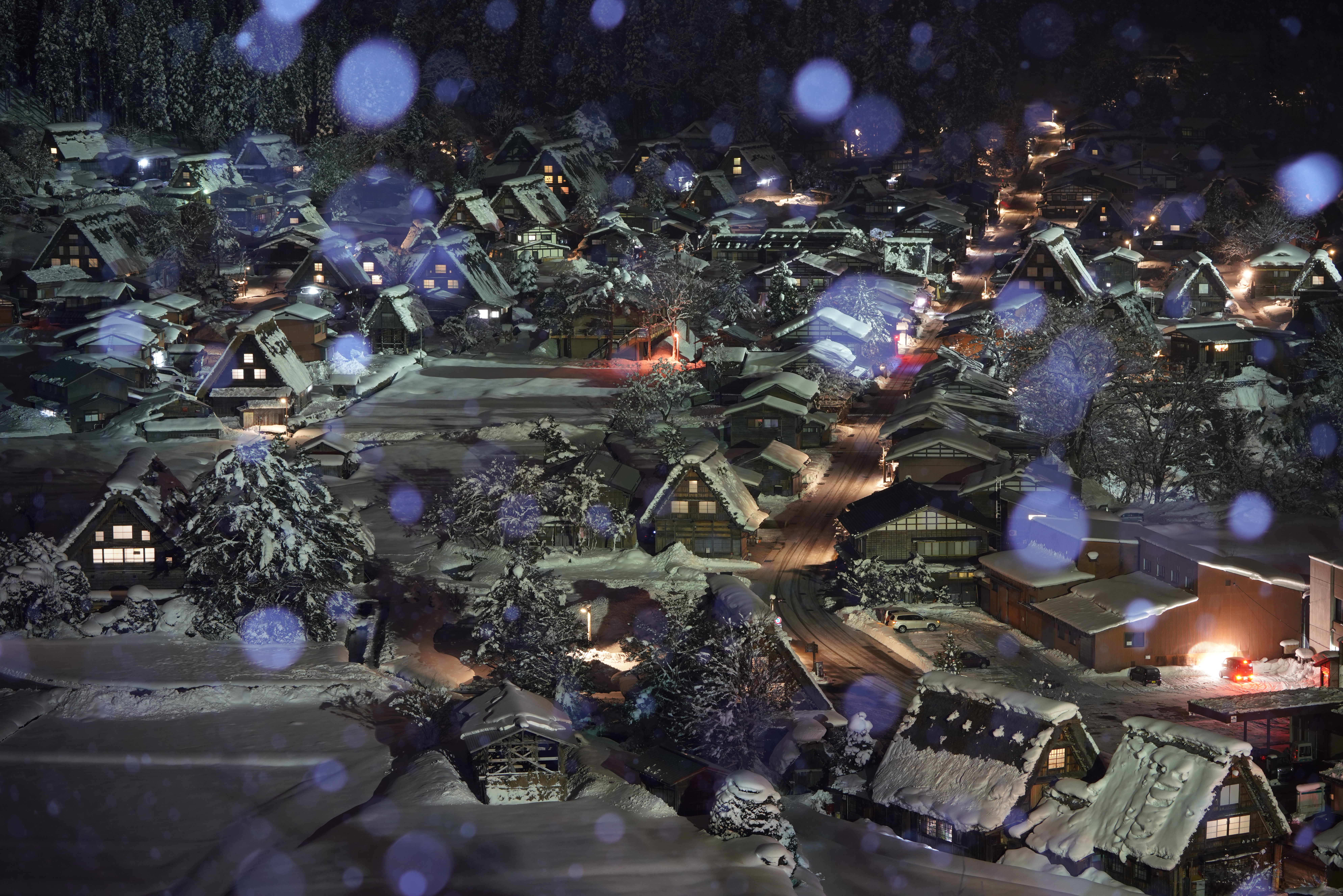 【作例】マジックアワーの時間帯も過ぎ、完全に空が暗くなってくると、海外からの団体さんもさすがに撤収しはじめたので、ようやく斜面から解放され展望台の最前列に。しばらくすると、白いモノが舞ってきた。そう、今回の真の目的はこの“雪フラッシュ”撮影だったのだ。撮影データ/ソニーα7R III FE100-400mm F4.5-5.6 GM OSS(100mm域) 絞り優先オート F6.3 10秒 ISO640 WB:太陽光(ブルー6、マゼンタ2) クリエイティブスタイル:ディープ(彩度+1) DRO:OFF