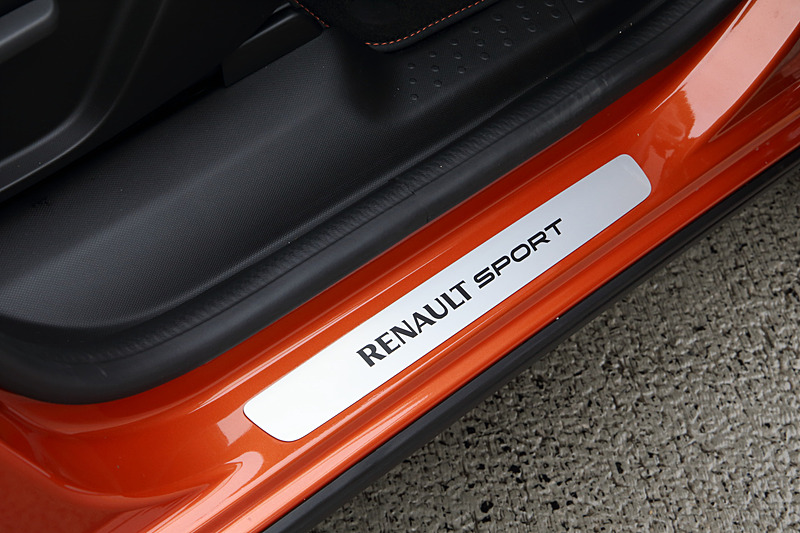 レザー調ドアトリムにオレンジステッチをあしらうとともに、エアコン吹き出し口、シフトレバーブーツリングにもオレンジのアクセントを採用した。また、“RENAULT SPORT”ロゴ入りキッキングプレート、アルミペダルなども装着してスポーティに仕上げたほか、アルパイン製のカーナビでは専用のオープニング画面が用意される