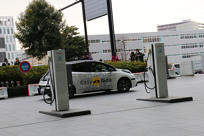 多数の報道陣が見守る中、実証実験用車両はEV（電気自動車）のリーフらしく静かにスタート。公道に出てすぐの交差点で赤信号を待ち、青信号を認識して横浜ワールドポーターズに向けて再スタートしていった