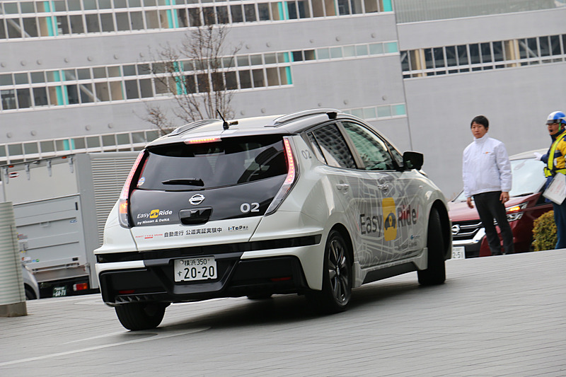 多数の報道陣が見守る中、実証実験用車両はEV（電気自動車）のリーフらしく静かにスタート。公道に出てすぐの交差点で赤信号を待ち、青信号を認識して横浜ワールドポーターズに向けて再スタートしていった