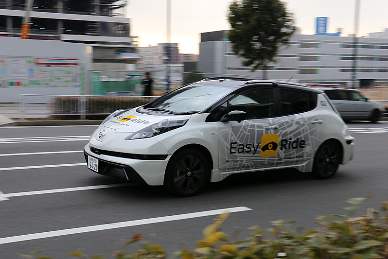 多数の報道陣が見守る中、実証実験用車両はEV（電気自動車）のリーフらしく静かにスタート。公道に出てすぐの交差点で赤信号を待ち、青信号を認識して横浜ワールドポーターズに向けて再スタートしていった