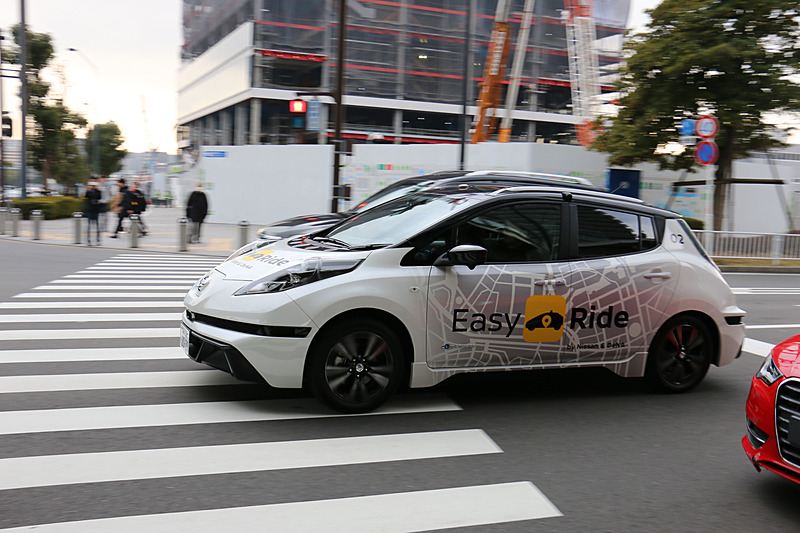多数の報道陣が見守る中、実証実験用車両はEV（電気自動車）のリーフらしく静かにスタート。公道に出てすぐの交差点で赤信号を待ち、青信号を認識して横浜ワールドポーターズに向けて再スタートしていった