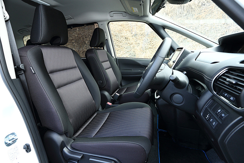 ブラックを基調としたe-POWER ハイウェイスター Vのインテリア。フロントガラスに遮音中間膜を入れるとともに、4層構造のセンターカーペットの装備（日産初採用）、ダッシュインシュレーターの構造変更など、ガソリン車に対して25ものアイテムを追加して遮音性が高められた。また、カーナビ下に「チャージモード」「マナーモード」のスイッチが設けられたのも新しい。なお、セレナ e-POWERの乗車定員は7名（2列目がキャプテンシート）のみのラインアップ