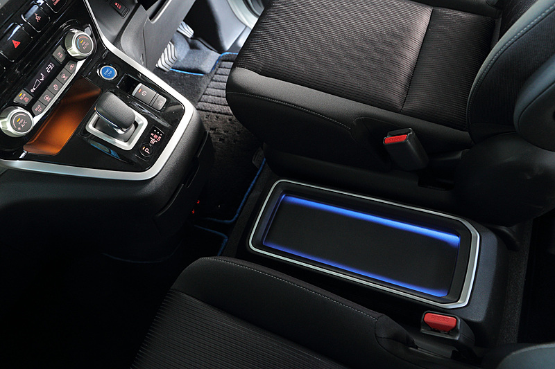 セレナ e-POWERではシフトノブやスタータースイッチにブルーアクセントを与えるとともに、メーターまわりにブルーアクセント・フィニッシャーを採用。間接照明（ブルーライティング）付きのフロントセンタートレイも装備する