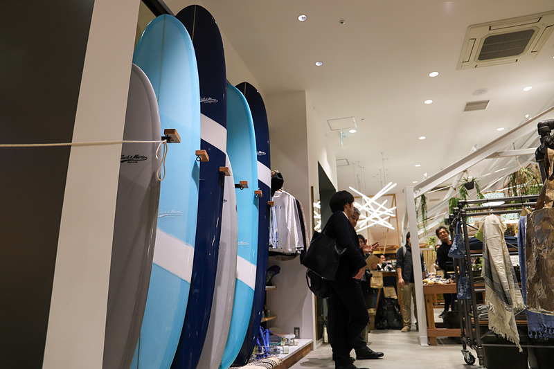 クルマから少し離れたところにはアパレルやリネン類などナチュラルなイメージの商品のほか、アクティブなイメージを想起させるサーフボードを展示