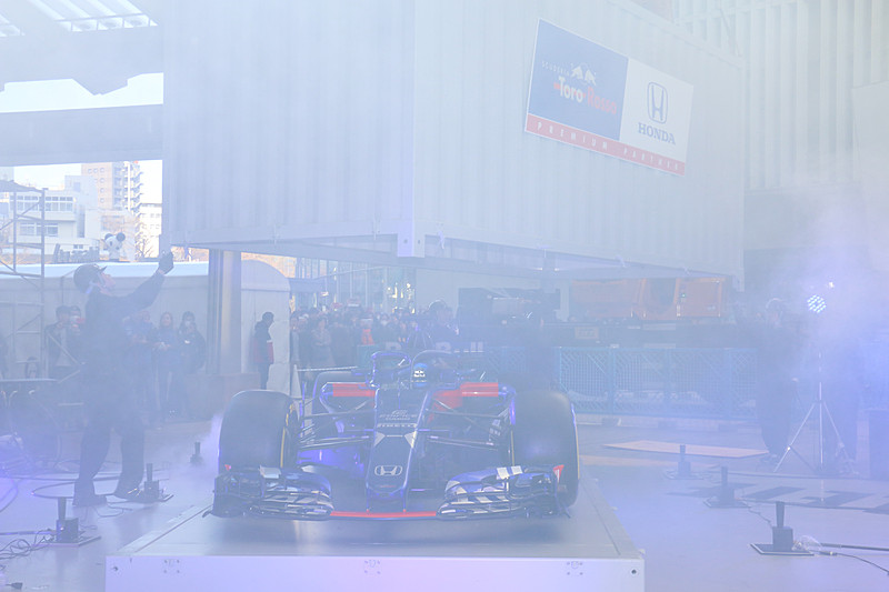 クレーンを使ってステージ上に移動されたコンテナ内からニューマシンが登場